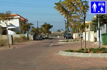 בתמונה נראה רחוב משולב, המרוצף באבנים משתלבות.
בצד ימין של הדרך מוצב תמרור מלבני כחול (תמרור 226), ובתוכו סמלים לבנים של רכב, מבוגר, וילד המשחק בכדור.