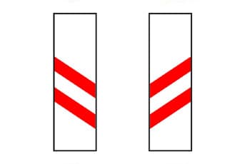 בתמונה מוצגים שני תמרורים מלבניים לבנים וניצבים. בכל אחד מהתמרורים יש שני פסים אלכסוניים אדומים.