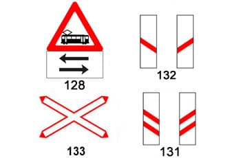 התמונה מציגה ארבעה תמרורים ממוספרים הקשורים למפגש מסילת ברזל.
תמרור 128 הוא משולש אזהרה עם ציור של רכבת קלה, ותחתיו שלט מלבני עם שני חיצים בכיוונים מנוגדים.
תמרור 133 הוא בצורת איקס (X) עם מסגרת אדומה.
תמרורים 131 ו-132 הם שלטים מלבניים אנכיים עם פסים אלכסוניים אדומים: שני פסים ב-131 ופס אחד ב-132.
