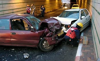 תמונה של תאונת דרכים בין שני כלי רכב בתוך מנהרה. חזיתות המכוניות מעוכות באופן קשה, ולידן נראה איש הצלה מארגון 'איחוד הצלה' מטפל באירוע.