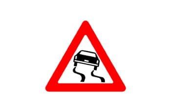 תמרור אזהרה משולש עם מסגרת אדומה. במרכז התמרור יש איור של רכב שחור שמחליק, ומתחתיו שני קווים שחורים מתפתלים המדמים סימני החלקה על הכביש.