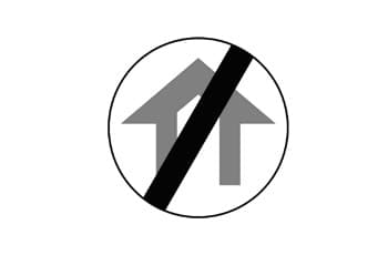 תמרור עגול שבתוכו איור של אזור בנוי בצבע אפור. קו אלכסוני שחור חוצה את האיור.