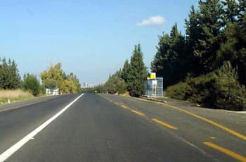 בתמונה נראה כביש דו-סטרי עם קו הפרדה רצוף לבן במרכזו. מימין לכביש ישנו מפרץ עצירה לאוטובוס עם תחנה. הכביש מתעקל קלות בהמשך הדרך, באופן שמגביל את שדה הראייה לפנים.