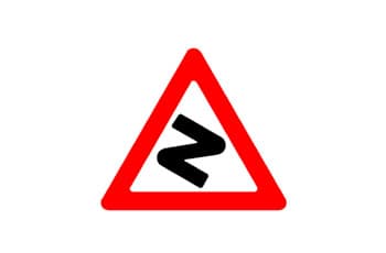 תמרור אזהרה משולש עם מסגרת אדומה, שבמרכזו סמל שחור של דרך מפותלת המתחילה בעיקול ימינה.