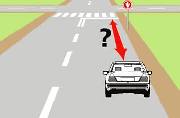 בתמונה נראה כביש המתקרב לצומת, שלפניו מסומן קו עצירה רציף. בצד הדרך ניצב תמרור עצור, שהוא מתומן אדום עם כף יד לבנה במרכזו. סימן שאלה וחץ אדום מצביעים על המרחק בין חזית הרכב לקו העצירה.