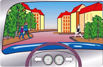 מבט מתוך רכב על רחוב באזור מגורים. משני צדי הכביש, על המדרכות, נראים ילדים סמוך לשפת הכביש. אין במקום תמרורים או סימון של מעבר חצייה.