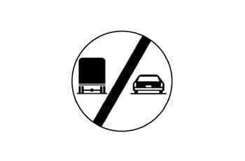 תמרור עגול עם מסגרת שחורה. בתוך התמרור יש איור של משאית בצד שמאל ורכב פרטי בצד ימין, וקו אלכסוני שחור עבה חוצה את כל התמונה.