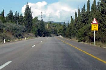 בצד ימין של כביש דו-סטרי מוצב תמרור אזהרה משולש (120) המראה פיתול ימינה ואז שמאלה (עקלתון). מתחתיו ישנו שלט מלבני צהוב עם הכיתוב "האט" בעברית ו-"SLOW" באנגלית.