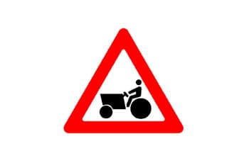 תמרור משולש עם מסגרת אדומה, ובמרכזו סמל שחור של טרקטור עם נהג.