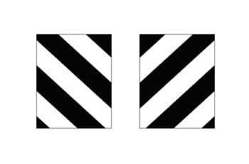 שני תמרורים מלבניים זהים, זה לצד זה. כל תמרור מורכב מפסים אלכסוניים עבים בצבעי שחור ולבן לסירוגין.