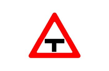 תמרור אזהרה משולש עם מסגרת אדומה, שבמרכזו סמל שחור של צומת T.