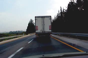 מבט מתוך רכב הנוסע קרוב מאחורי משאית גדולה. המשאית חוסמת את שדה הראייה של הנהג קדימה אל הכביש.