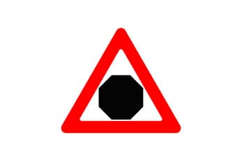 תמרור אזהרה משולש עם מסגרת אדומה, שבתוכו צורת מתומן שחורה.