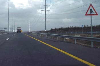 בצד ימין של כביש רב-נתיבי מוצב תמרור אזהרה משולש עם מסגרת אדומה. בתוך התמרור יש סמל שחור של כביש ראשי ישר, שאליו מצטרף ומשתלב כביש נוסף מהצד הימני.